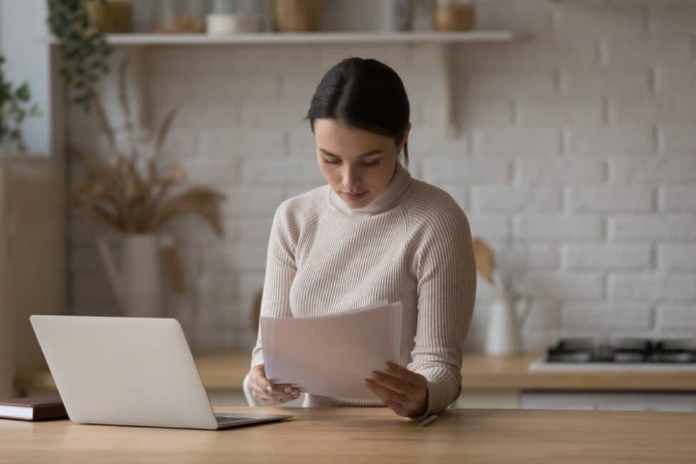 Woman reading important documents as she finds out she owes taxes