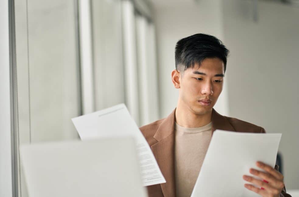 Young man reviewing important documents to claim the student loan interest deduction