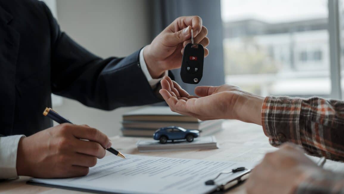 Car dealer giving the car keys to a new buyer