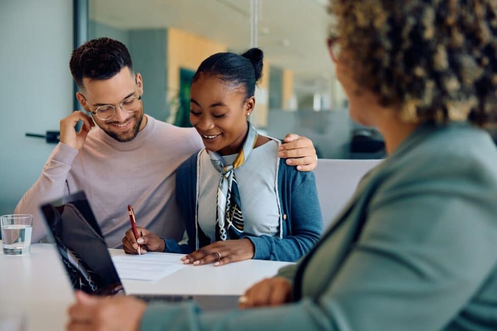 Couple speaking with a loan officer  to consolidate their debt 