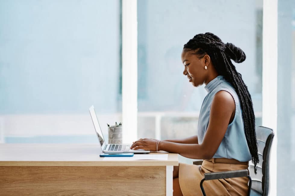 Young black businesswoman working on a laptop in an office alone